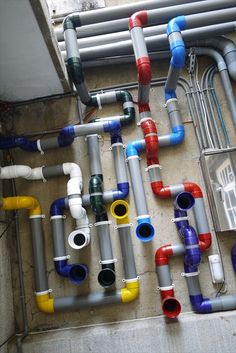 many different colored pipes are lined up on the wall