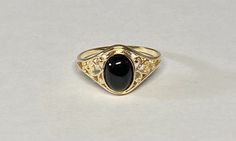 Add a touch of elegance to your jewelry collection with this stunning 10K yellow gold ring featuring a beautiful oval-shaped 8mm x 6mm natural black onyx stone. The intricate filigree design adds a delicate touch to this dainty ring, making it a perfect accessory for any occasion. Crafted in the United States with the utmost care and attention to detail, this fine piece of jewelry is sure to make a statement and become a cherished addition to your collection. Crafted of solid 10 karat yellow gol Classic Black Filigree Ring For Formal Occasions, Classic Black Filigree Rings, Black Oval Filigree Ring For Formal Occasions, Black Oval Ring With Intricate Design, Black Oval Rings With Intricate Design, Oval Black Filigree Jewelry, Black Oval Filigree Jewelry, Vintage Black Oval Filigree Ring, Black Oval Victorian Signet Ring