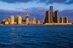 the city skyline is seen from across the water at dusk, with clouds in the sky