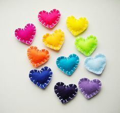 small felt hearts arranged in different colors on a white surface