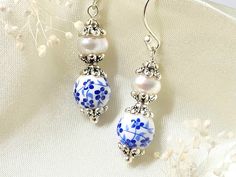 Tiny blue flowers, adorn these dainty porcelain earrings. They feature genuine freshwater pearls, that are embellished with antique silver bead caps. These elegant earrings, will make a lovely addition to your jewelry collection!   Please note that each natural pearl will vary slightly in shape and number of striations, making each piece one of a kind! I always try to choose pearls that closely match each other, and look as close to the pictures as possible.  Product details: * Silver plated ear Nickel-free Czech Glass Earrings For Wedding, Nickel-free Czech Glass Wedding Earrings, Elegant Blue Czech Glass Flower Earrings, Elegant White Czech Glass Jewelry, Vintage Handmade White Pearl Earrings, Elegant Flower Earrings With Czech Glass, Elegant Flower Earrings With Round Beads As Gift, Elegant Round Beads Flower Earrings As Gift, Blue And White Earrings