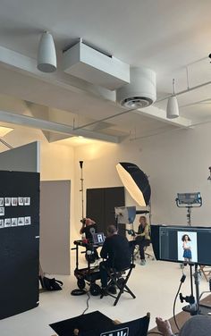 people are sitting in chairs with cameras and lighting equipment around them on the set of a television show