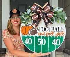 a woman is holding up a football and ball yard staker for the front door