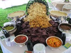 a table topped with lots of different types of food on top of a white table cloth