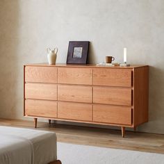 a wooden dresser sitting next to a bed in a bedroom