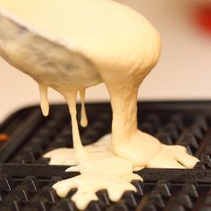 a person pouring sauce on top of a waffle