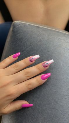 a woman's hand with pink and white nail polish holding a gray book in front of her