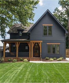 a large blue house sitting on top of a lush green field