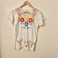 Gorgeous Unused Vintage Top. Imvintage From The 70s. Off White. Colorful Embroidery. 19" Pit To Pit So I'm Guessing A Medium. Cutouts On Hem. Mexican Made. Cotton Polyester Blend. Great For Summer And Vacation. White Vintage Top With Vintage Print, Vintage Crew Neck Spring Blouse, Vintage Crew Neck Blouse For Spring, Vintage Crew Neck Blouse For Summer, Vintage White Blouse With Floral Print, Vintage White Floral Print Blouse, Vintage White Summer Blouse, Vintage White Blouse For Summer, Vintage Embroidered Cotton Tops