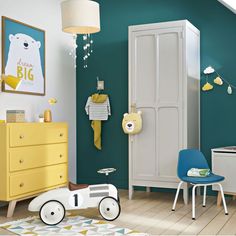 a child's room with green walls and white furniture, including a yellow toy car