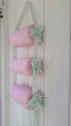 a pink and green wall hanging decoration with bows on the top, along with polka dots