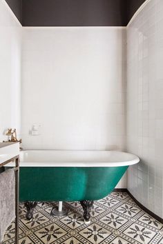 an old fashioned bathtub in a bathroom with black and white tiles on the floor