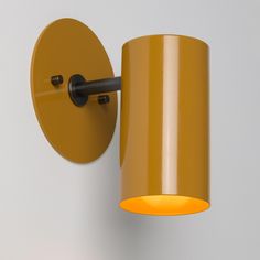 a yellow wall light mounted on the side of a white wall