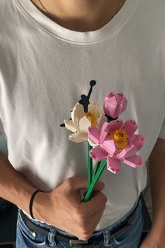 a person holding flowers in their hands and wearing a t - shirt with the word love written on it