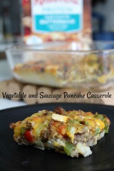 vegetable and sausage pancake casserole on a black plate next to the casserole dish