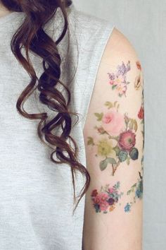 a woman with a flowered arm tattoo on her left arm and right arm behind her head