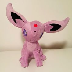 a pink stuffed animal sitting on top of a table