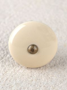 a close up of a white door knob on a carpeted floor with no one around it