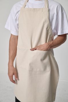 a man wearing an apron with his hands in the pocket