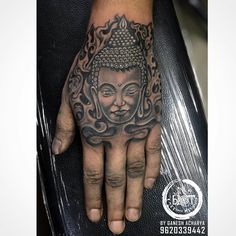 a hand with a buddha tattoo on it