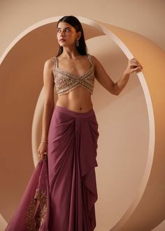 Layers for the festive season? This ethnic mulberry ensemble makes layering easy. Featuring a lightweight organza cape, pleated draped dhoti skirt and crop bustier with exclusive hand embroidery cut-dana, sequins & delicate transparent drops hanging at the hem. The cape is speckled with the same embroidery work, lending subtle bling to the look. Cape Organza, Cher Looks, Dhoti Skirt, Cutdana Work, Sequins Blouse, Cape Set, Lehenga Designs Simple, Pleated Drapes, Women Kurta