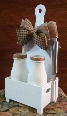 three bottles are sitting in a holder with a bow