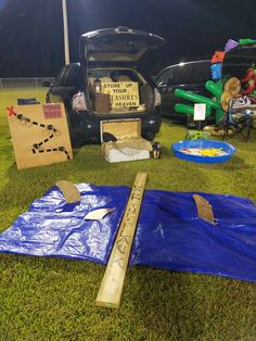 there is a blue tarp and some items on the ground next to a car