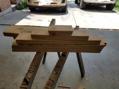 two cars parked next to each other in front of a building with wooden planks