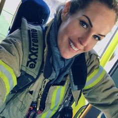 a woman in a fire fighter uniform taking a selfie