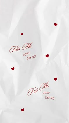 some red hearts on white paper with the words kiss me don't say no