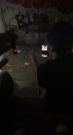 two people sitting in the dark with their cell phones