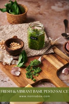 fresh and vibrant basil pesto sauce on a cutting board next to garlic, parsley and other herbs