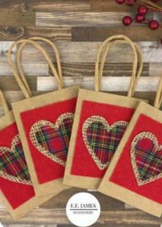 four small bags with hearts on them sitting next to some red berries and other decorations