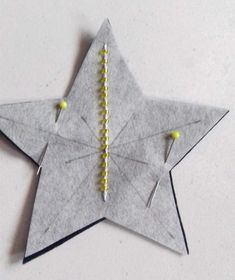 an origami star with yellow beads on it