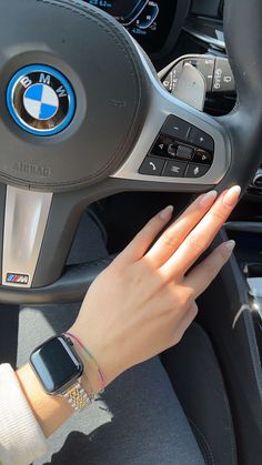 a woman is holding her hand on the steering wheel