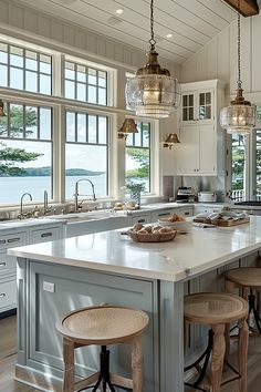 a large kitchen with an island in the middle and three stools at the end