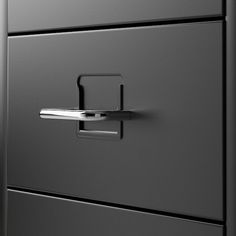 a black filing cabinet with two drawers and a handle on the bottom drawer that is open