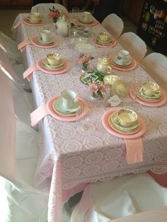 the table is set with tea cups and saucers