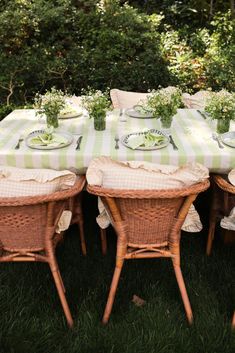 the table is set with green and white checkered cloth on it, surrounded by wicker chairs