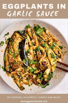 eggplants in garlic sauce on a white plate with chopsticks next to it