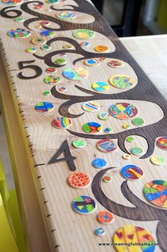 a wooden table topped with lots of different colored buttons and numbers on it's sides