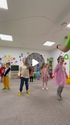 a woman teaching children how to dance in a classroom