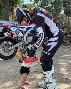 a man helping a little boy to ride a dirt bike