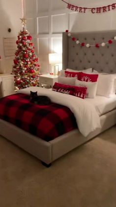 a bedroom decorated for christmas with red and white decorations on the walls, bedding, and pillows