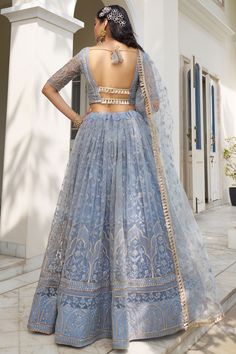 a woman in a blue lehenga with an open back