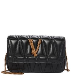 This black Virtus Small shoulder bag showcases a string of Vercase's signature codes. Made in Italy from V-quilted nappa leather, this compact piece has a magnetic, logo-embellished flap, which opens to reveal a Barocco-print interior fitted with three card slots. Detach the chain strap to style yours as an evening clutch. | Versace Virtus Small leather shoulder bag Bottega Bag, Versace Gold, Versace Bags, Small Quilts, Evening Clutch, Small Shoulder Bag, Quilted Leather, Nappa Leather, Chain Strap