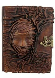 a brown leather journal with an image of a woman's face on the cover