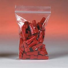 a bag filled with red legos sitting on top of a table