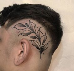 a man's head with a tattoo on the top of his head and leaves behind it