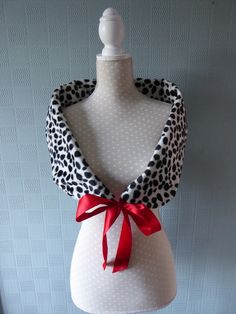 a white mannequin with a red bow on it's neck and polka dots